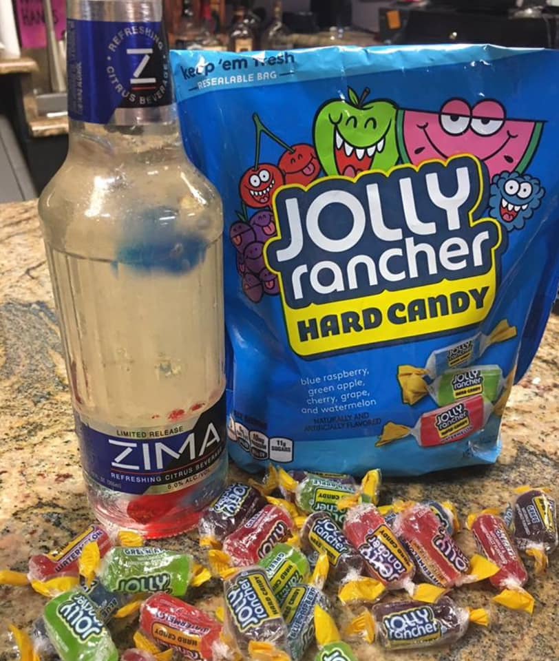 A bottle of Zima accompanied by Jolly Rancher Candies