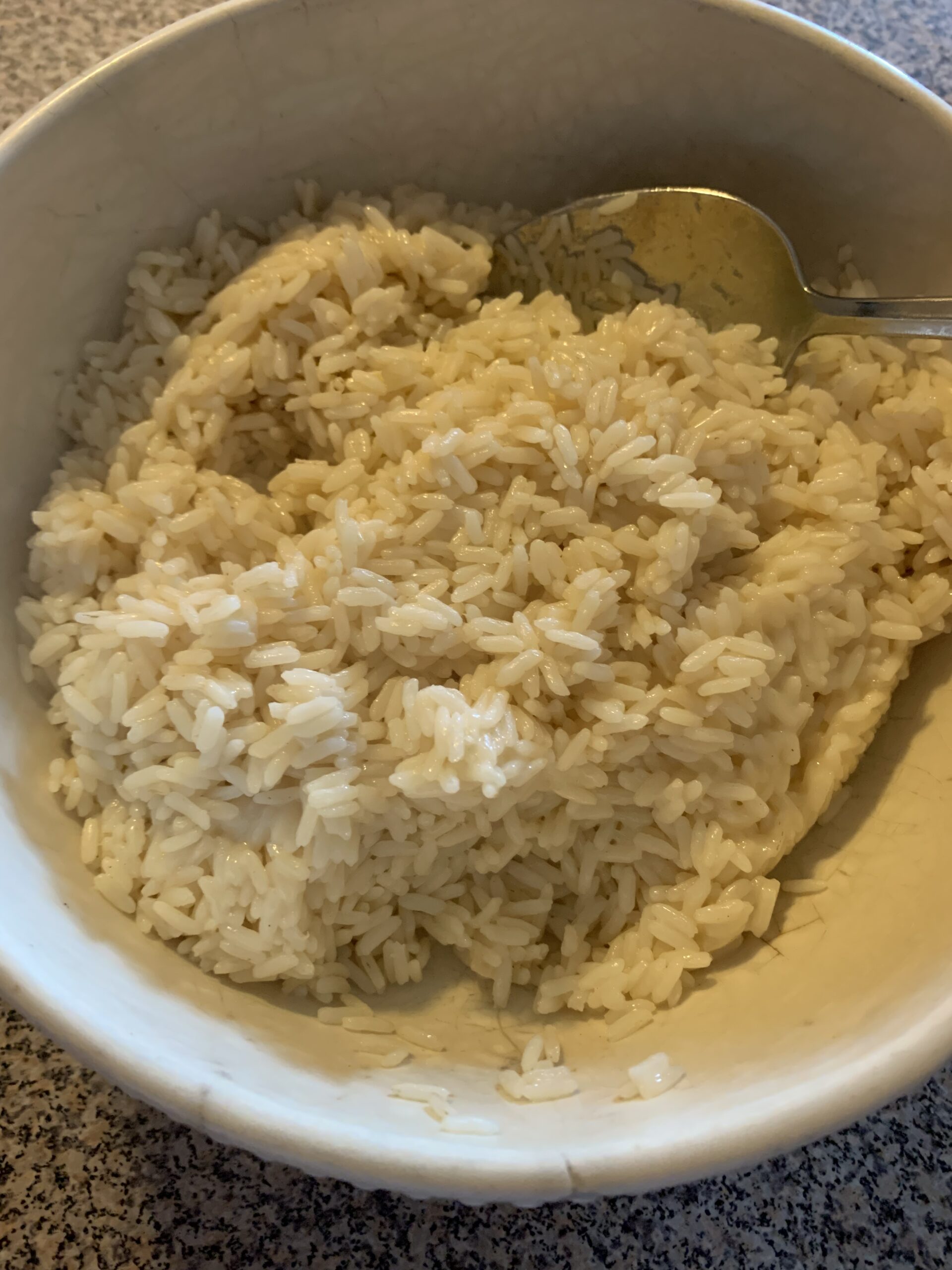 Bowl of white rice with a spoon.